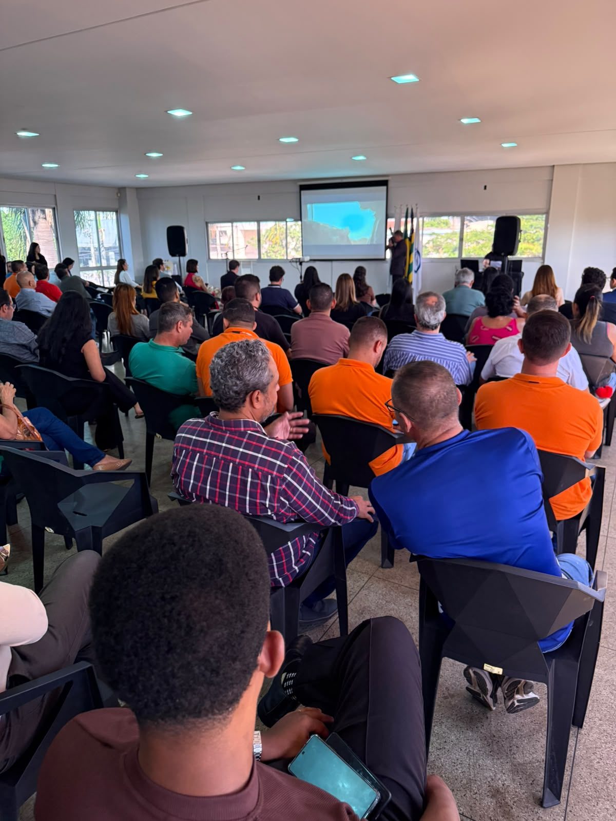 Plateia de trabalhadores e convidados acompanha as falas no auditório do SINTTEL-GO