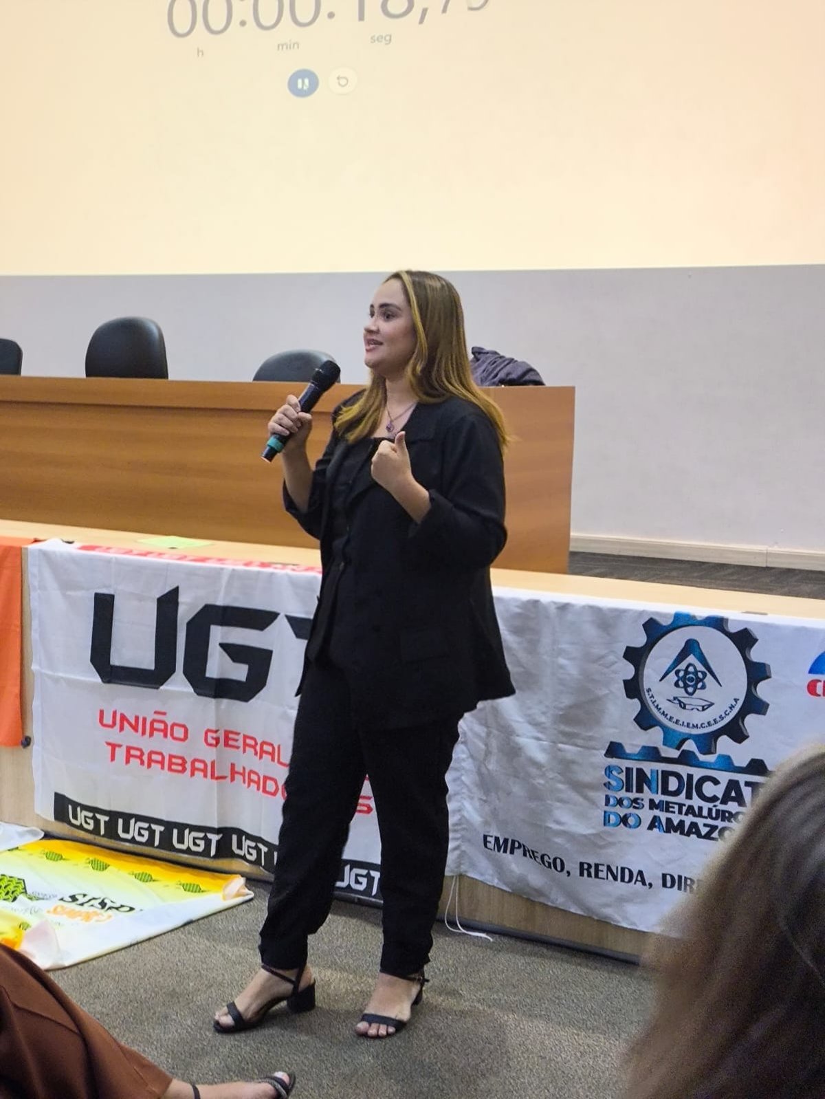 Ana Karolynne Bispo Fernandes com o microfone durante atividade da formação
